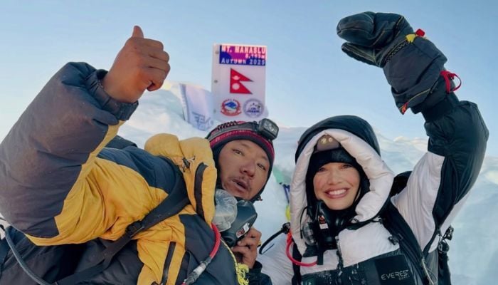 Mountaineer Nadia Azad poses with the Pakistan flag at the peak of Mount Manaslu in Nepal on September 26, 2025. — Instagram/@nadiaclimbs
