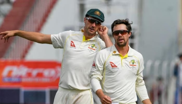 1349556_3807818_pat-cummins-travis-head-1_updates Australias captain Pat Cummins (left) speaks with Travis Head during the fifth day of the first Test between Pakistan and Australia at the Rawalpindi Cricket Stadium on March 8, 2022. — AFP